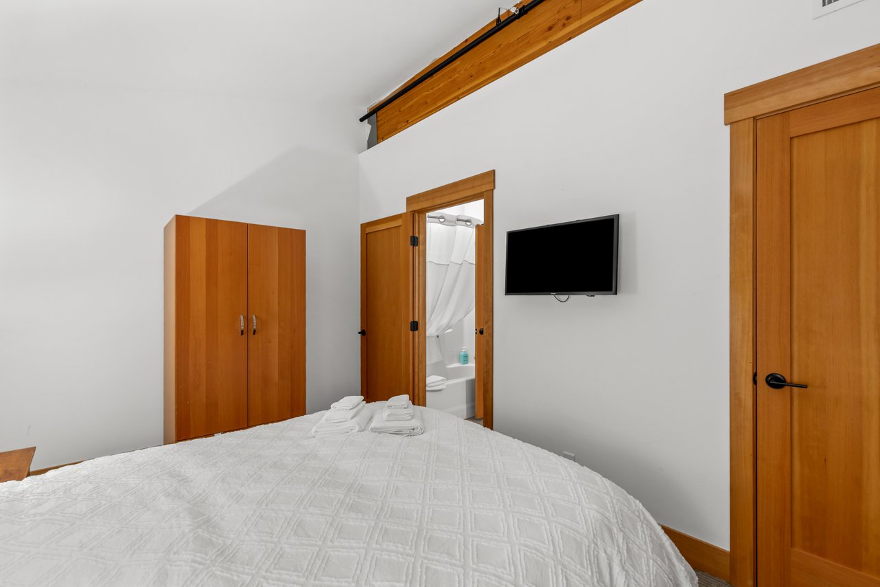 Bedroom has Queen Sized Bed and TV.